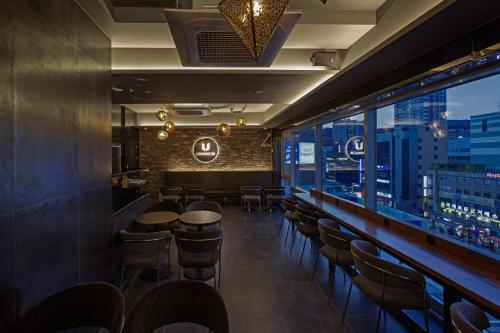a bar with stools and a view of the city at Busan Lounge 26 Hotel in Busan
