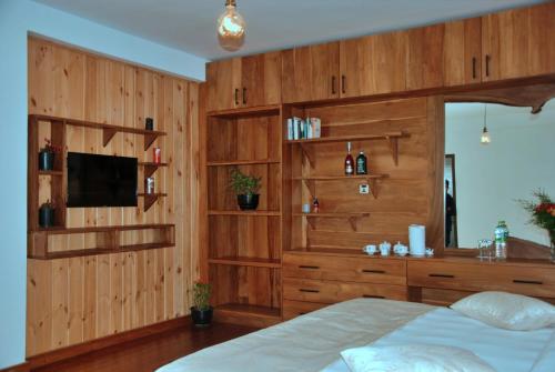 
a bedroom with a wooden bed and a wooden dresser at Cottage San Francesco in Nuwara Eliya
