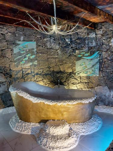 a stone fountain in front of a stone wall at ALOELUXVILLA COM " I " , for couples! Design by the local artist Salvado r in Conil