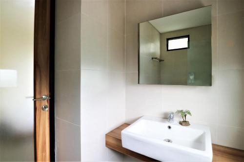 a bathroom with a white sink and a mirror at M Pavilion - BSD in Serpong