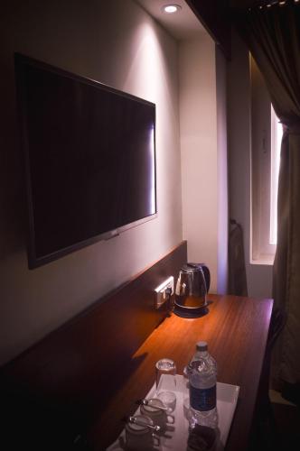 a room with a television and a table with two water bottles at Zoot Kochi Infopark in Cochin