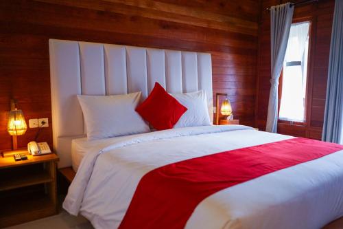 a bedroom with a large bed with red and white pillows at La'villaris hotel & resto in Kuta Lombok