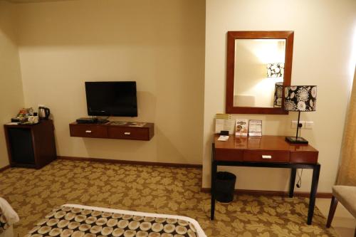Habitación con TV, mesa y espejo. en The Aures (formerly known as Keys Select The Aures), en Aurangabad