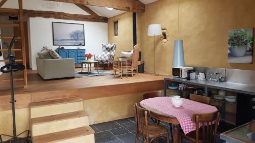 une cuisine et un salon avec une table et des chaises dans l'établissement Le Peyroutet, à Cazaux-Villecomtal