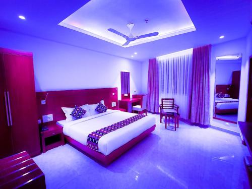een slaapkamer met een groot wit bed en een bureau bij Hotel Victoria International in Kattappana