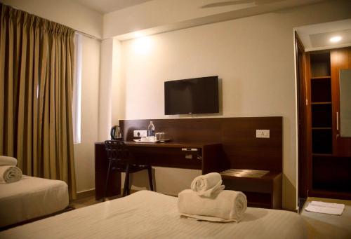 a hotel room with a desk and a television at Zoot Kochi Infopark in Cochin