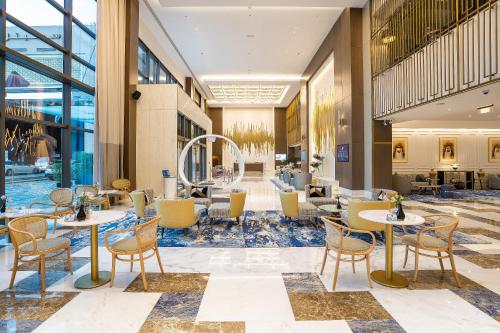 a lobby of a hotel with tables and chairs at Sofitel Dubai Jumeirah Beach in Dubai