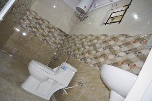 a bathroom with a toilet and a sink at hotel fortune suites in Bangalore