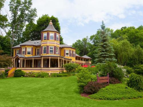 a large yellow house on a green lawn at Fairlawn Inn in Hunter