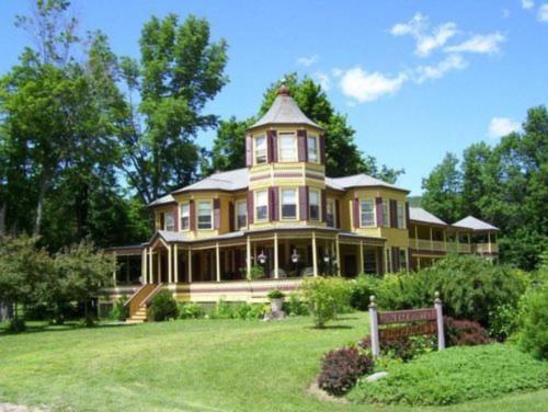 a large yellow house with a turret on a lawn at Fairlawn Inn in Hunter