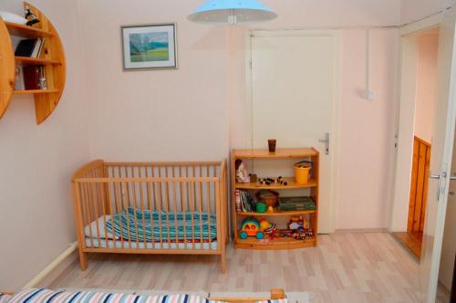 Habitación con cuna y estante para libros en Mecsek Vendégház, en Pécs