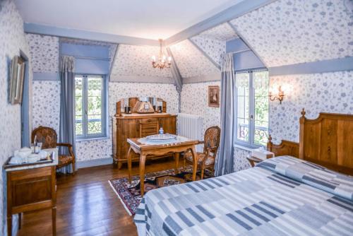 une chambre avec un lit, une table et des chaises dans l'établissement La Closerie de Fronsac, à Saint-Michel-de-Fronsac