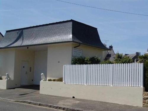 a white building with a black roof and a white fence at Chambres d'hôtes La Mansardière in Cancale