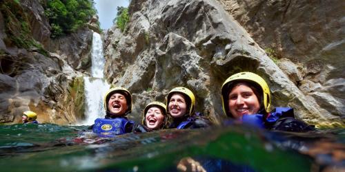 a group of people in the water in front of a waterfall at Un je ne sais quoi de Paradis in Les Vans