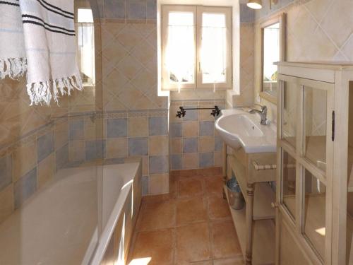 un bagno con vasca e lavandino di Mas Dansavan Chambres d'hôtes a Oppède