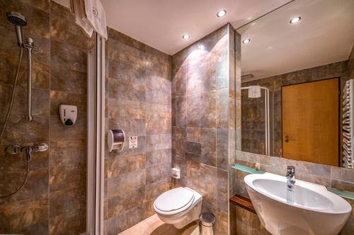 uma casa de banho com um lavatório, um WC e um chuveiro em Termál Kemping Apartmanok és Bungalók em Harkány