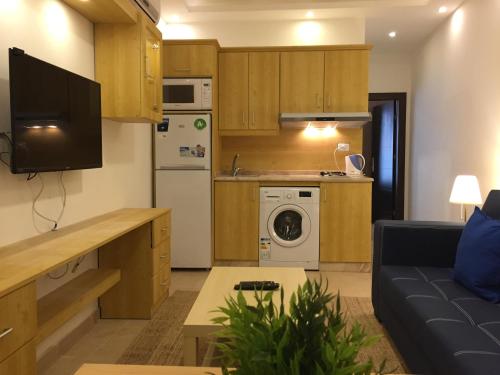 uma cozinha com uma sala de estar com um sofá e um micro-ondas em Superior Executive Apartment em Umm Uthainah