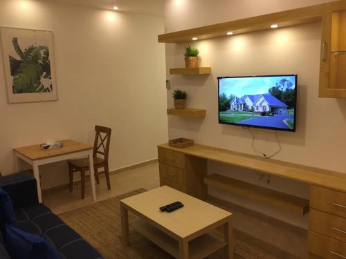 Superior Executive Apartment في Umm Uthainah: غرفة معيشة مع تلفزيون على الحائط