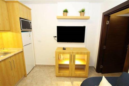 a small kitchen with a tv on a wall at The Royal Luxury City Budget Visit in Amman