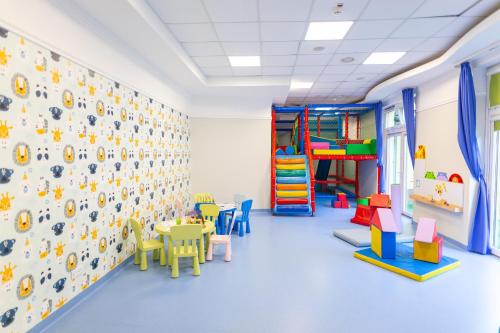 a childrens room with a play area and tables and chairs at Hotel Verde Montana Wellness & Spa in Kudowa-Zdrój