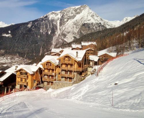 a ski lodge in the snow in front of a mountain at Black Diamond Sainte Foy Chalets in Sainte-Foy-Tarentaise