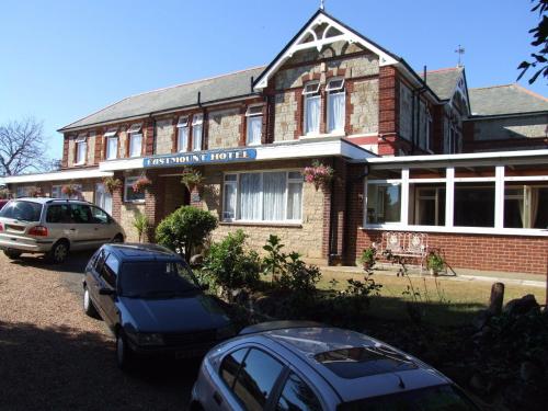 a building with two cars parked in front of it at Eastmount Hall Hotel in Shanklin