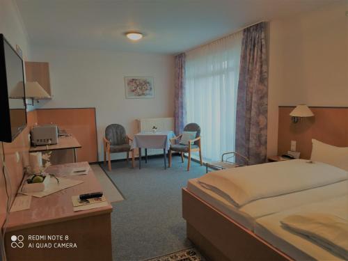 クロッペンブルクにあるHotel Diekgerdes Standardのベッドとテーブルが備わるホテルルームです。