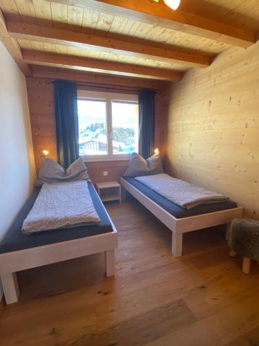 two beds in a room with a window at Bim See in Bettmeralp