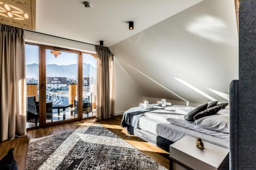 1 dormitorio con cama y ventana grande en Aparthotel Prestige, en Zakopane