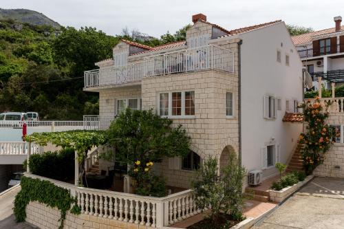 a large white house with a balcony on it at Apartments Orange Tree in Cavtat