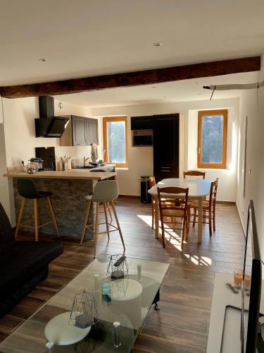 Il comprend un salon et une cuisine avec une table et des chaises. dans l'établissement Charmante maison de village, à Arbori