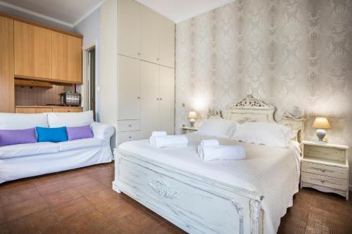 Un dormitorio con una cama blanca y un sofá. en Central Apartment, en Argostoli