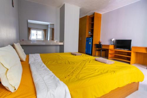 a large yellow bed in a room with a television at Fenix in Pathum Thani