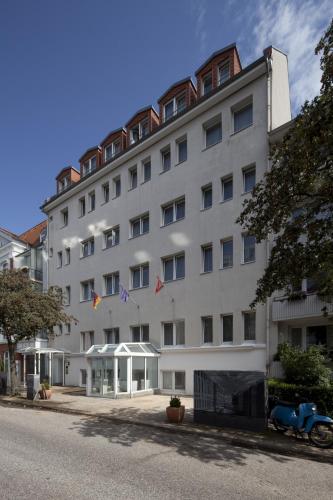 a large white building with kites in front of it at Heikotel - Stadtpark Residenz in Hamburg