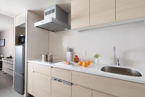 a kitchen with white cabinets and a sink at Oakwood Suites Yokohama in Yokohama