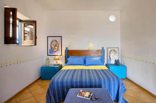 1 dormitorio con 1 cama de color azul y amarillo en Le case di Eolo - Santa Marina Salina, en Santa Marina Salina