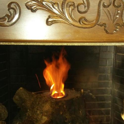a fireplace with a fire in it with flames at ''EPAVLIS boutique GALAXIDI'' in Galaxidhion