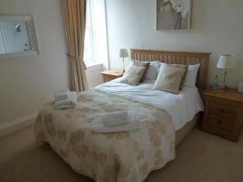 a bedroom with a bed with two towels on it at The Manor House in Puncknowle