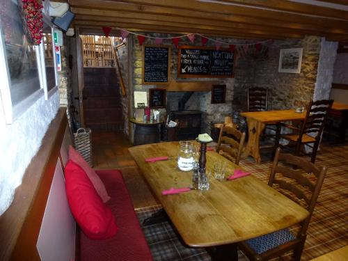 a wooden table and chairs in a restaurant at The Manor House in Puncknowle