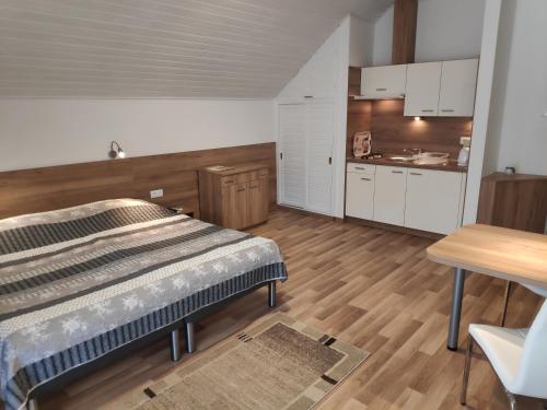 ヘーヴィーズにあるKlára Villa Apartmanの広いベッドルーム(ベッド1台付)、キッチンが備わります。