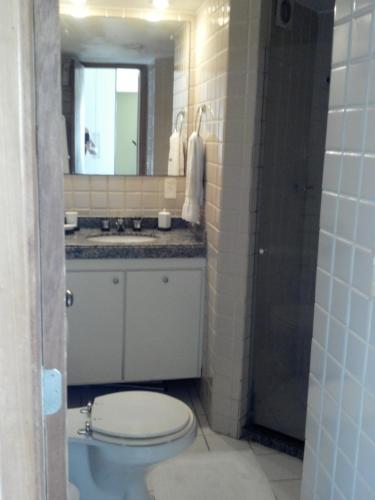 a bathroom with a toilet and a sink and a mirror at Apartamento no Rio Vermelho - Bairro Boêmio de Salvador in Salvador