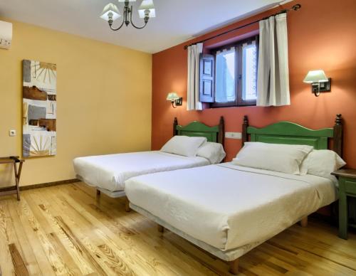 A bed or beds in a room at Hostal Almadiero