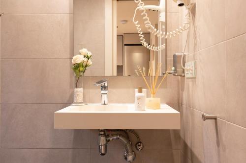 La salle de bains est pourvue d'un lavabo et d'un miroir. dans l'établissement Chic Apartments Barcelona, à Barcelone