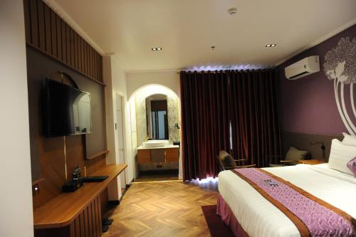a hotel room with a bed and a television at B.O.B HOTEL SIGNATURE in Cao Lãnh