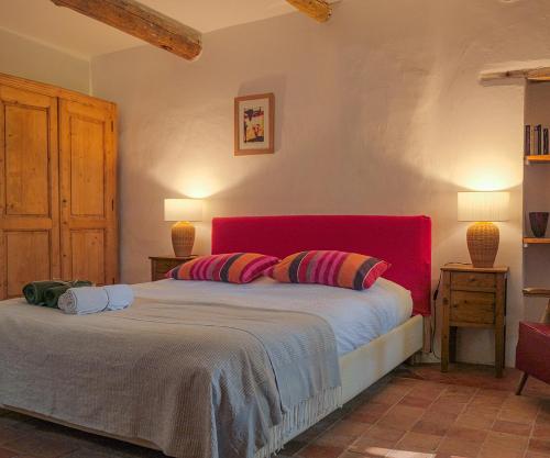 a bedroom with a large bed with a red headboard at Montjoia in Le Thor