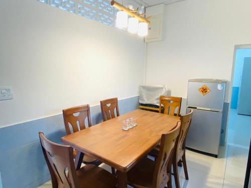 a dining room table with chairs and a refrigerator at 關廟 86民宿 包棟 