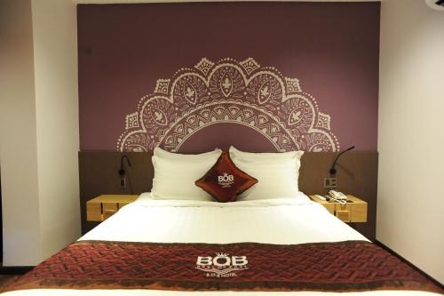 a bedroom with a bed with a large headboard at B.O.B HOTEL SIGNATURE in Cao Lãnh