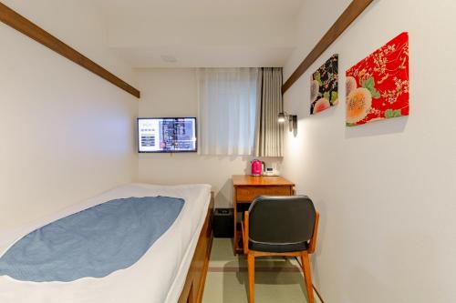 東京にあるThe OneFive Tokyo Shibuyaのベッドと机と椅子のある寝室