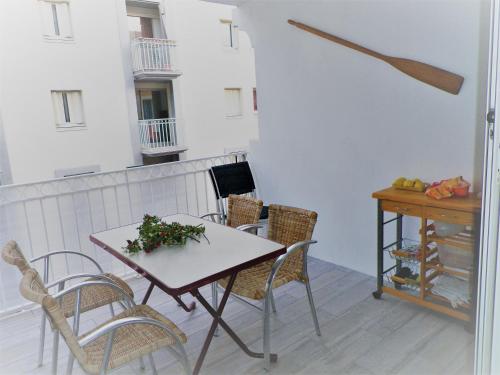 Cette chambre dispose d'une table, de chaises et d'un bureau. dans l'établissement Amarine joli T3 Centre Ville terrasse parking et vélos, à Sète