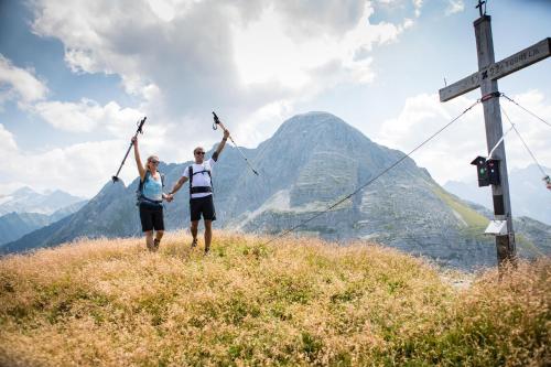a man and woman standing on a mountain with their arms in the air at Anja's Schönblick - Bed & Breakfast in Gerlos